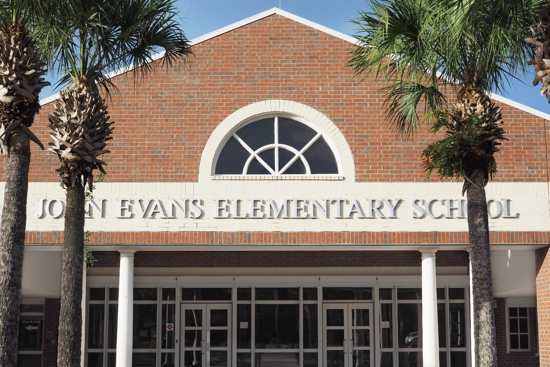Entrance of Evans Elementary School framed by four palm trees.